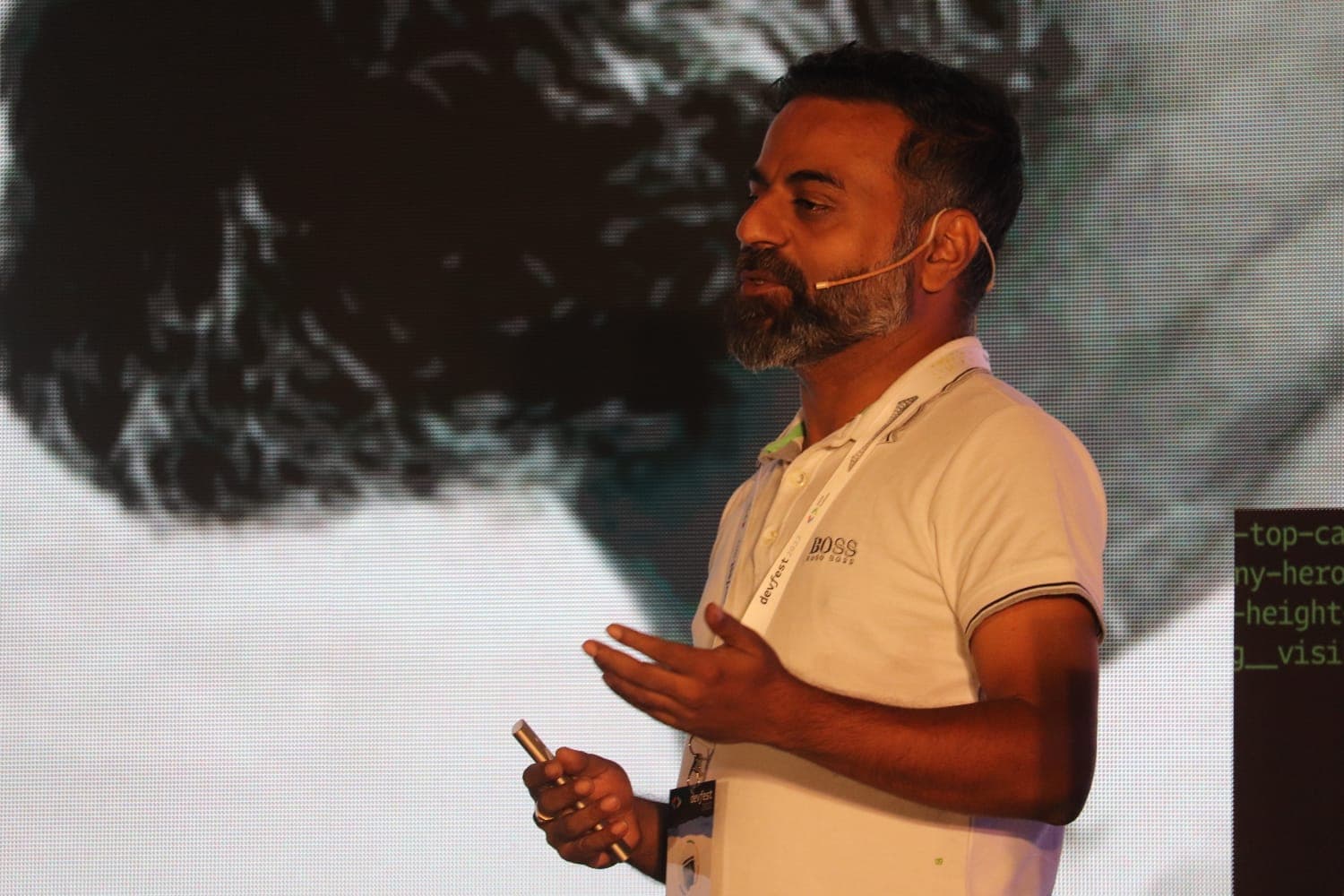 Aloke Majumder speaking on stage at a DevFest conference